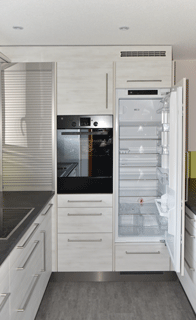 Küche mit Kühlschrank und Backofen